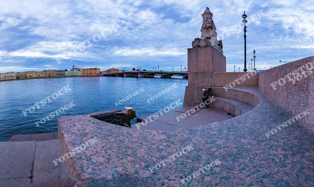 Фотография утреннего Санкт-Петербург, Россия, сделанная в период белых ночей. На изображении показан Васильевский остров с набережной реки Нева. В кадре запечатлён Благовещенский мост и египетский сфинкс, установленный на набережной. Этот фотоснимок передаёт спокойную атмосферу раннего утра, мягкий свет белых ночей и исторический облик Петербурга. Фото подчёркивает уникальность российских городов и архитектурное наследие Санкт-Петербурга. Иллюстрация может использоваться как изображение, картинка или слайд, посвящённые утренним видам и культурным символам города.
